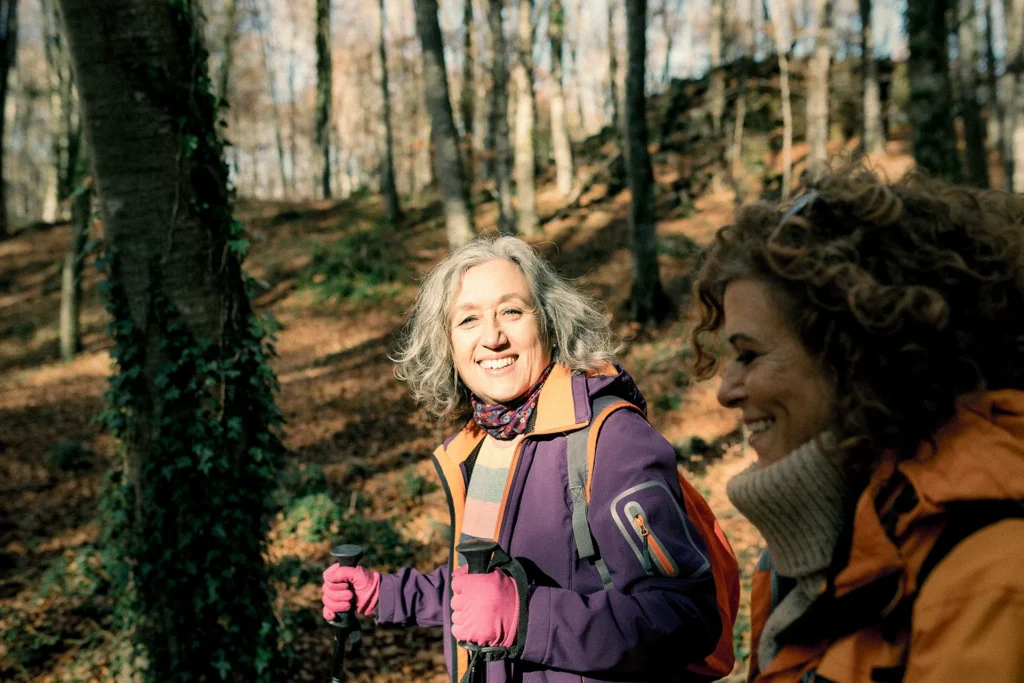two women hiking in a forest in autumn  