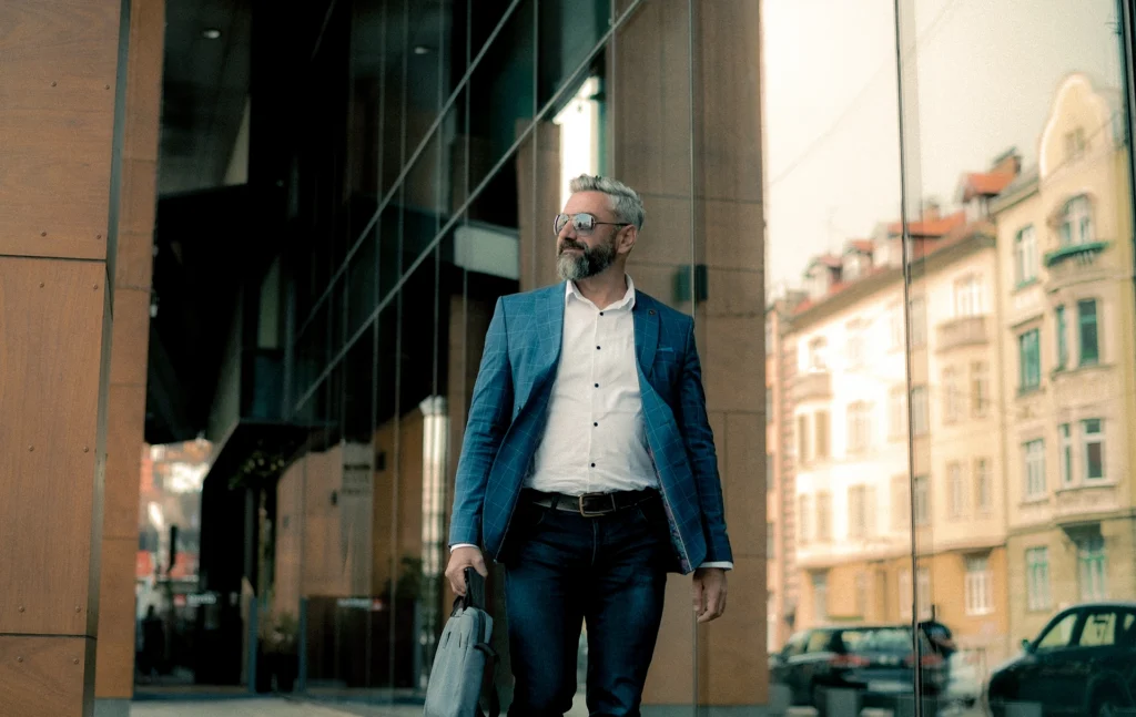 middle age man in a suit walking with a briefcase outside and office building 