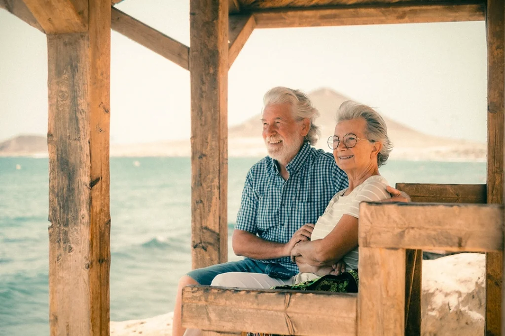 couple sitting by the beach on a bench