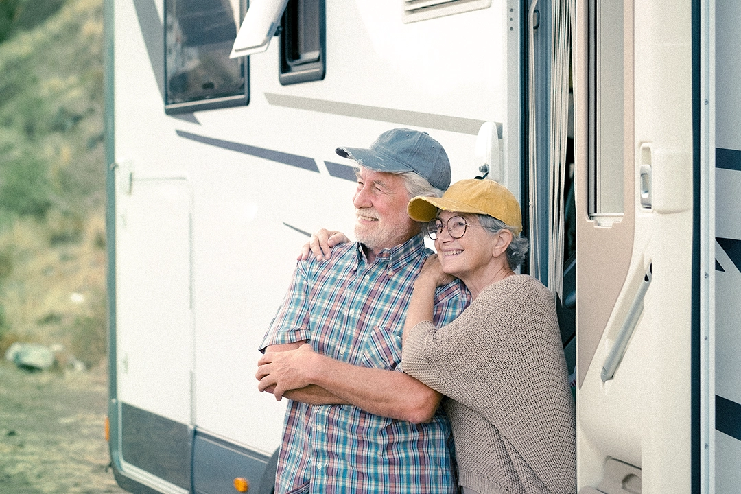 couple standing in front of rv smiling